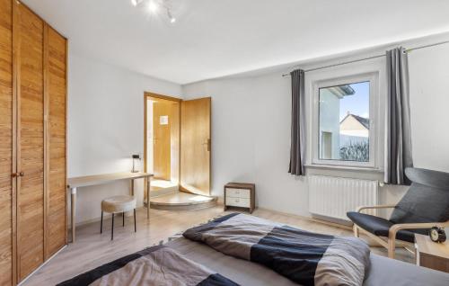 een slaapkamer met een bed, een stoel en een raam bij Awesome Apartment In Rtha With Kitchen in Rötha