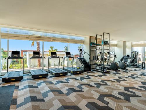 a gym with treadmills and ellipticals in a building at Rixos Gulf Hotel Doha in Doha