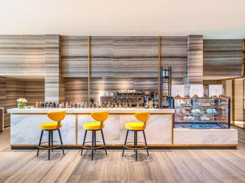 a bar with yellow stools in a restaurant at Rixos Gulf Hotel Doha in Doha
