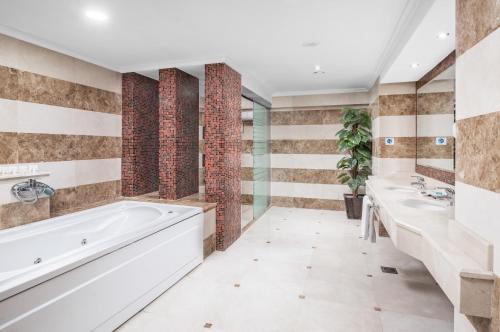 - Baño con 2 lavabos, bañera y 2 lavabos en Al Aqeeq Madinah Hotel en Medina