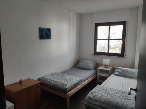 Habitación con 2 camas individuales y ventana. en Ferienwohnung mit 123qm für 8 Personen mit sehr großem Garten, einfache Innen-Ausstattung, en Leipzig