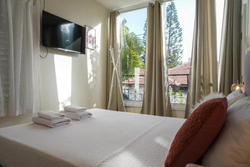 ein Schlafzimmer mit einem Bett mit Handtüchern und einem Fenster in der Unterkunft Villa Rosen at Ramat Hahayal TLV in Tel Aviv