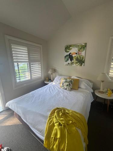 ein Schlafzimmer mit einem Bett mit einer gelben Decke darauf in der Unterkunft Poppies Lakeview Terrace - 2 Bedroom in Cams Wharf