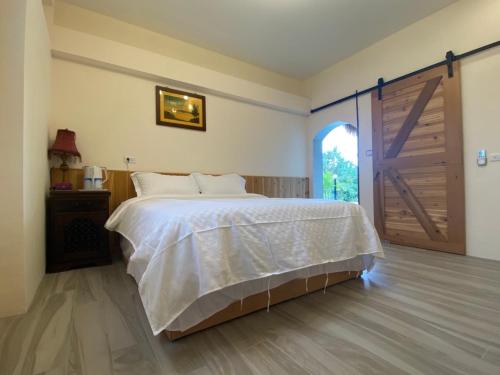 a bedroom with a bed and a sliding door at 鳳凰懷舊 in Chenggong