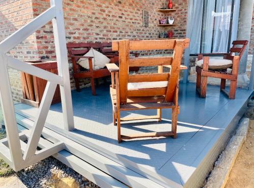 a wooden rocking chair sitting on a porch at Mo’Ville Guest House in Maseru