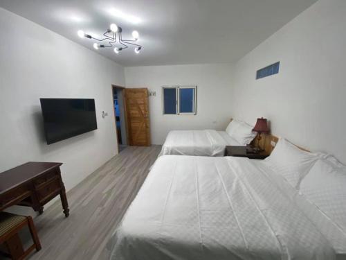a bedroom with a large bed and a tv at 鳳凰懷舊 in Chenggong