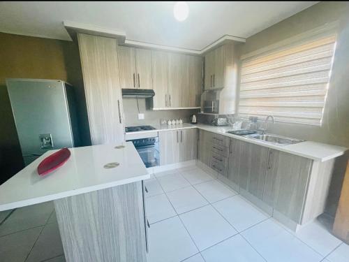 a kitchen with wooden cabinets and a red bowl on a counter at Mo’Ville Guest House in Maseru