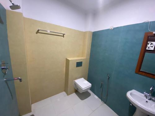 a bathroom with a toilet and a sink at HOTEL MADHAV INN in Haridwār