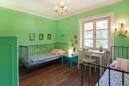 a bedroom with green walls and a bed and a desk at Cottage a Bossolasco con piscina in Niella Belbo
