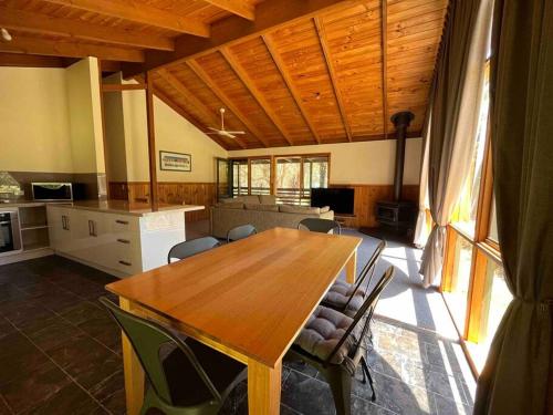 a kitchen and dining room with a wooden table and chairs at Howqua Haven in Howqua