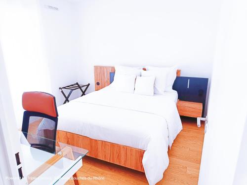 une chambre avec un lit blanc et une chaise rouge dans l'établissement Appart Standing Free Parking Balcony Terrasse & Clim, à Marseille