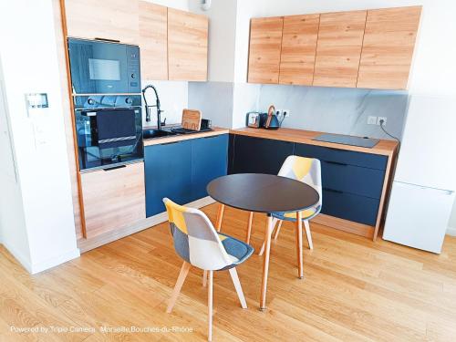 une petite cuisine avec une table et deux chaises dans l'établissement Appart Standing Free Parking Balcony Terrasse & Clim, à Marseille