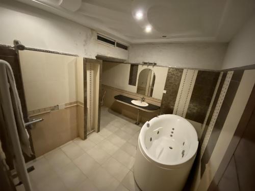 a bathroom with a bath tub and a sink at Harveys Guest House in Islamabad
