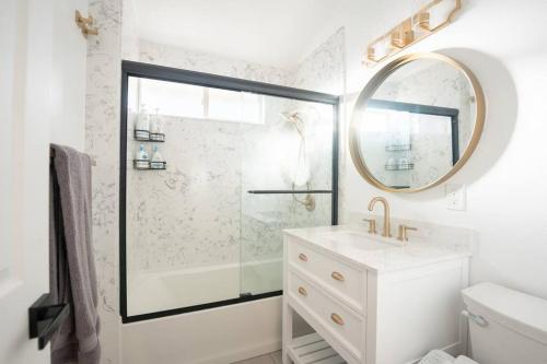 a bathroom with a shower and a sink and a mirror at Luxury Disneyland Home: Family & Exec Friendly in Anaheim
