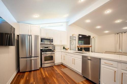a kitchen with white cabinets and stainless steel appliances at Luxury Disneyland Home: Family & Exec Friendly in Anaheim
