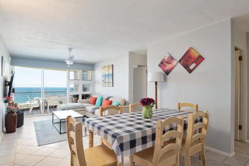 - un salon avec une table à manger offrant une vue sur l'océan dans l'établissement Chakas Cove 95, à Ballito