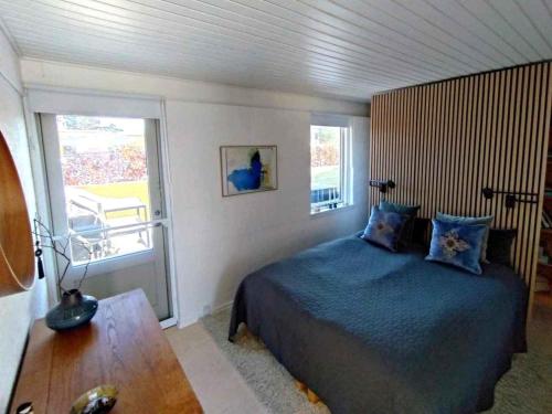 a bedroom with a bed and a large window at Cozy Summerhouse With Spectacular Views! in Ølsted
