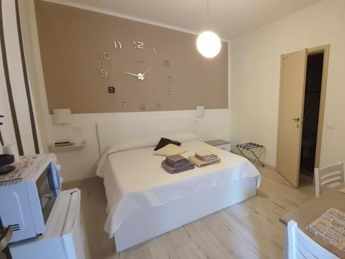 a room with a bed and a clock on the wall at Le camere di Sabrina con bagno in camera in Sarzana
