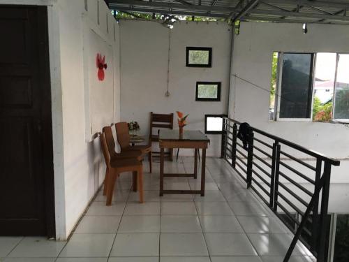 a room with a table and chairs on a porch at Orion Jaya House in Ketapang