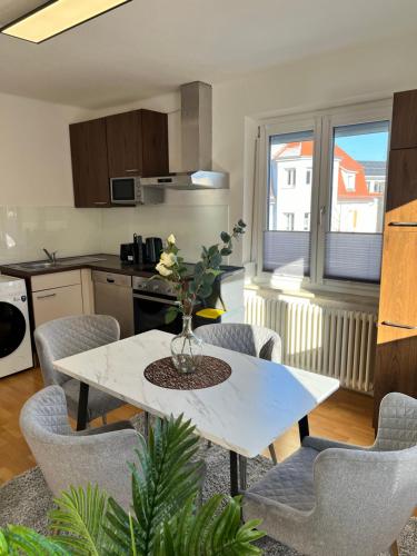 里斯河畔比伯拉赫的住宿－Feel like Home 2，厨房以及带白色桌椅的用餐室。