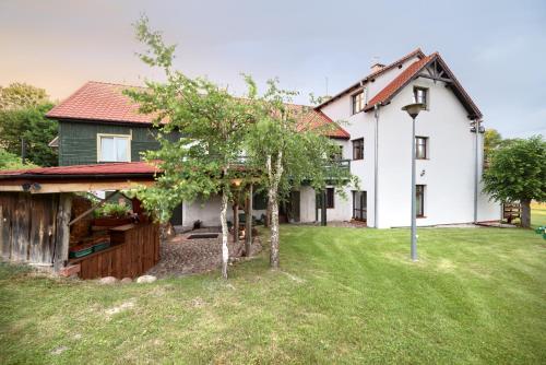 a large white house with a yard at Gościniec Zielony Domek in Mrągowo