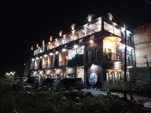 a large building with lights on it at night at Sapo Rumbia Villa & Hotel in Berastagi