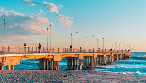 a group of people walking on a pier over the ocean at Hotel Tiffany in Marina di Massa