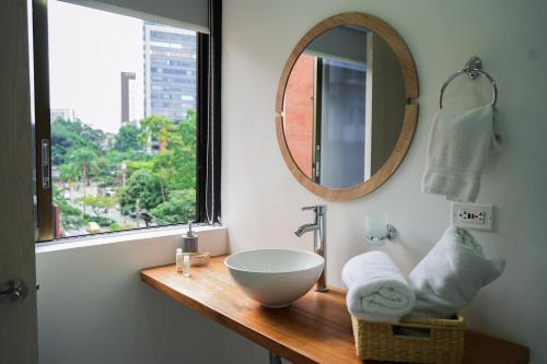 a bathroom with a sink and a mirror at Hotel Bambu Milla De Oro in Medellín