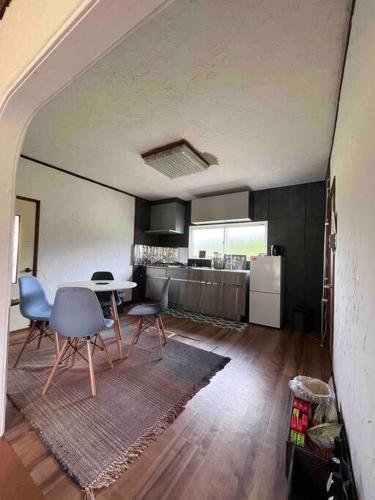 a kitchen with a table and chairs in a room at Sound Garden Biei - Forest suite in Biei