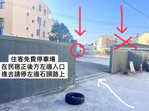 a sign on a wall with a tire next to a street at Yi Yuan Homestay in Lukang