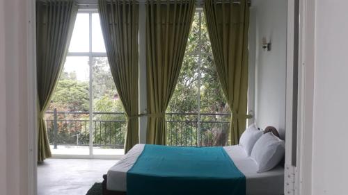 um quarto com uma cama e uma grande janela em Kandy Fortress em Kandy