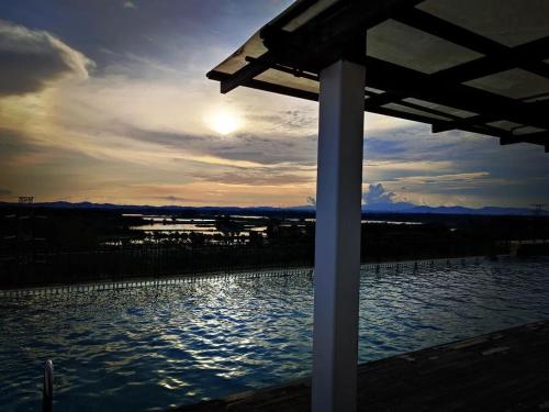 una vista de un cuerpo de agua al atardecer en Kampar Bonvoy Champs Elysees 4pax Homestay, en Kampar