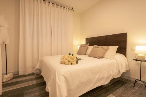 Un dormitorio con una gran cama blanca con flores. en La casona de Torremocha de Jarama, en Torremocha de Jarama