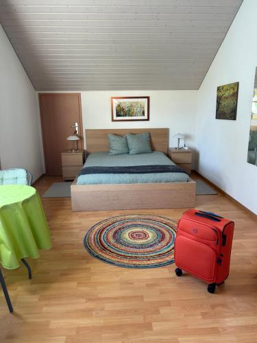 um quarto com uma cama e uma mala vermelha em Queen Guest Room em Mont-sur-Rolle