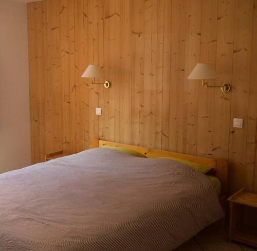 1 dormitorio con 1 cama con 2 luces en la pared en Chalet montagne Savoie Domaine Skiable Valmorel, en La Lechere