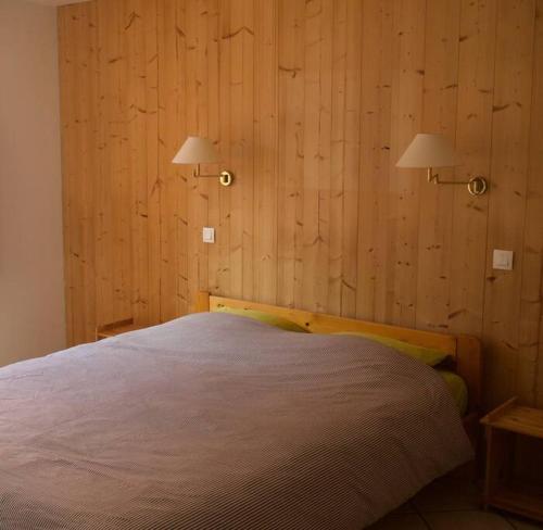 ein Schlafzimmer mit einem Bett mit zwei Lichtern an der Wand in der Unterkunft Chalet montagne Savoie Domaine Skiable Valmorel in La Lechere