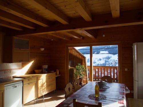 une cuisine avec une table et une grande fenêtre dans l'établissement Chalet montagne Savoie Domaine Skiable Valmorel, à La Lechere
