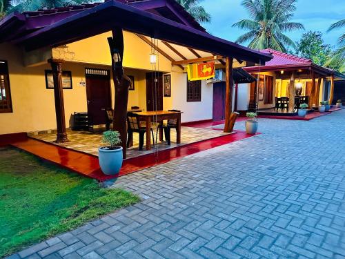 Cette maison dispose d'une terrasse avec une table. dans l'établissement Green Sapphire Holiday Resort Wilpaththu, à Wilpattu