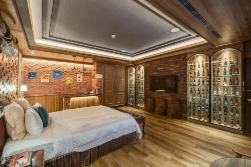 a bedroom with a bed and a television and wine bottles at Merry Day Motel Zhonghe Branch in Zhonghe