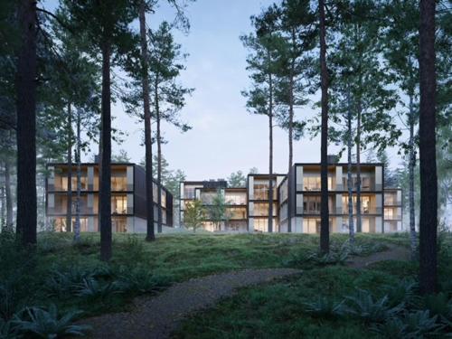 a building in the middle of a field with trees at Marina Apartment am See mit Pool und Sauna in Bad Saarow