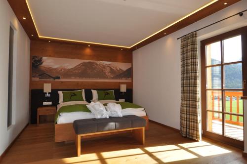 a bedroom with a bed and a large window at Hotel-Garni "Das Seebichl" in Achenkirch