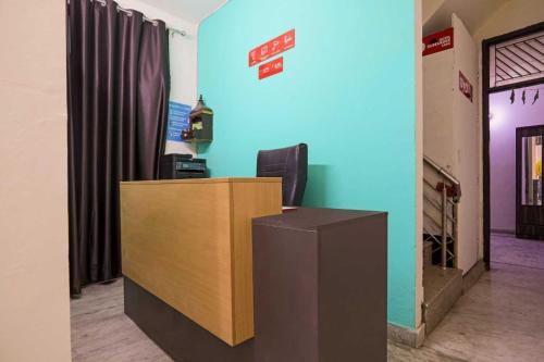 un bureau avec un bureau et un mur bleu dans l'établissement Hotel O D 3 residency, à Ghaziabad