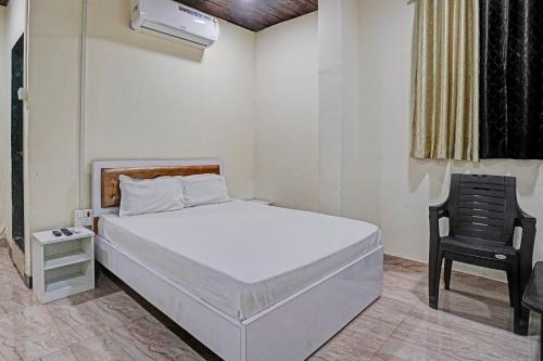 1 dormitorio con 1 cama blanca y 1 silla en OYO Sai Villa Lodging & Bording, en Bombay
