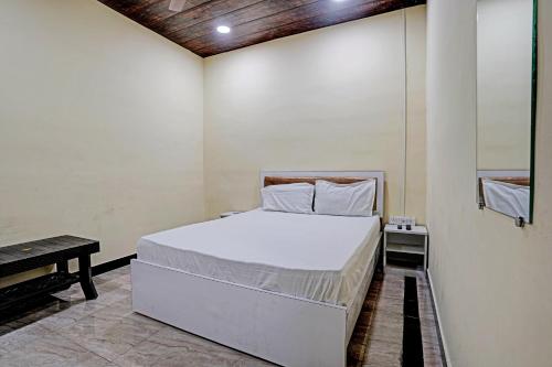 1 dormitorio con cama blanca y mesa en OYO Sai Villa Lodging & Bording, en Bombay