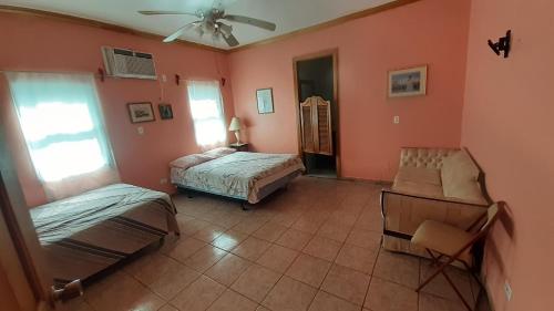 特拉的住宿－La Casa Blanca De Mis Sueños，一间卧室配有两张床和吊扇
