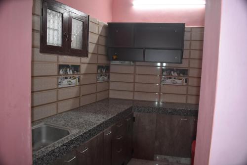 una piccola cucina con lavandino e televisore di Harisri Homestay a Madurai