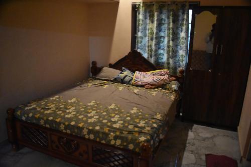 ein kleines Bett in einem Zimmer mit Fenster in der Unterkunft Harisri Homestay in Madurai