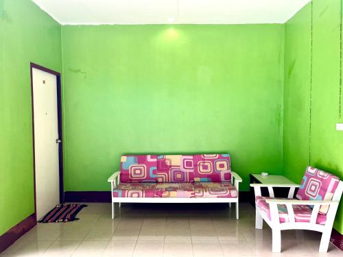 a green room with a couch and a table at Khao Chang View Resort in Phangnga