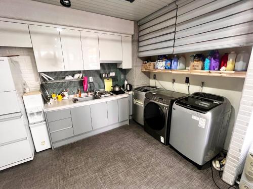 a kitchen with a washing machine and a sink at Ho Home Tel in Seoul