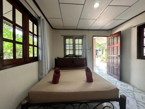 łóżko w pokoju z dwoma butami w obiekcie Phangan Lodge w mieście Baan Tai